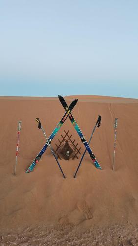 a group of four ski poles in the sand at Akwabir camp in El Gouera