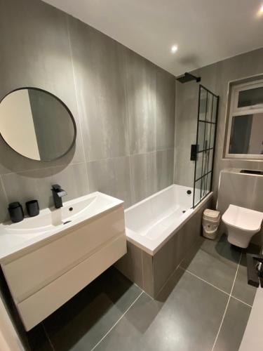 a bathroom with a sink and a tub and a mirror at Summer budget double room in Stone Grove