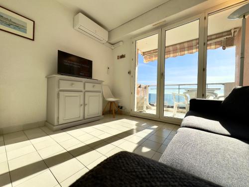 un salon avec un canapé et une télévision dans l'établissement Vogue By SCLS Locations, à Cannes