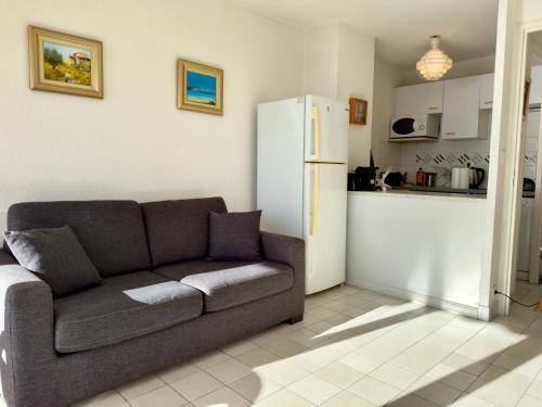 un salon avec un canapé et une cuisine dans l'établissement Vogue By SCLS Locations, à Cannes