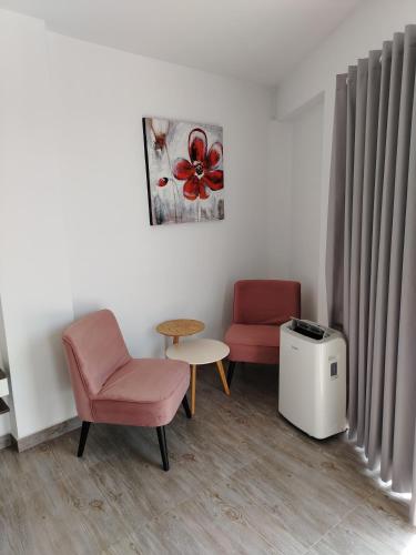 a waiting room with two chairs and a table and a table at Casa Yuraq Hotel Boutique in Chincha Alta