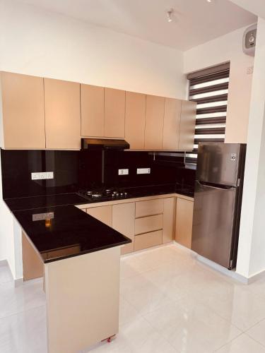 a kitchen with a black and stainless steel refrigerator at URBAN 17 - Experience comfort & convenience in Moratuwa