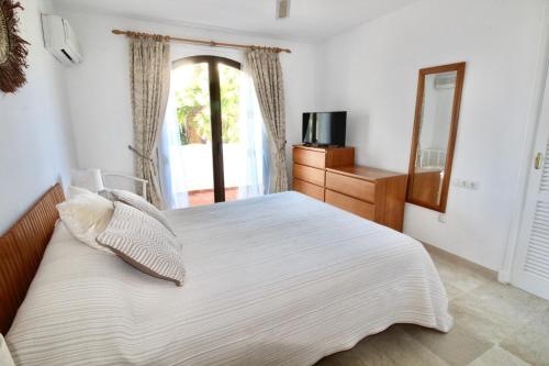 ein Schlafzimmer mit einem großen weißen Bett mit einem Fenster in der Unterkunft Beautiful Three-Bedrooms El Rancho Villa in Atamaría