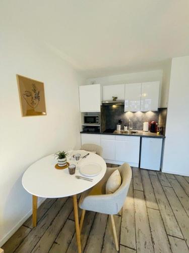 une petite cuisine avec une table et des chaises blanches dans l'établissement Le Studio de Théa - Private Parking - 2 Guests, au Mans