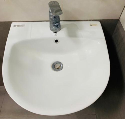 a white sink in a bathroom with a faucet at AN Homestay&coffee in Di Linh