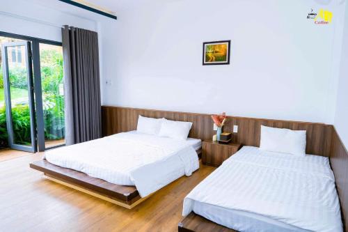 a bedroom with two beds and a window at AN Homestay&coffee in Di Linh