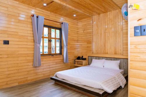 a bedroom with a bed in a wooden room at AN Homestay&coffee in Di Linh
