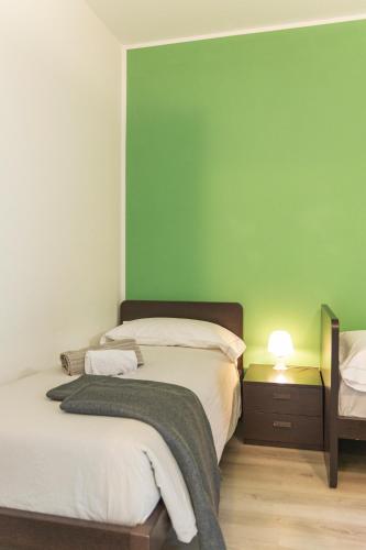 two beds in a room with a green wall at Il Giardino Di Lory in Vercana