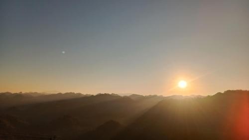 a view of the sun setting over a mountain range at Higland Homestay Bac Ha in Bắc Hà