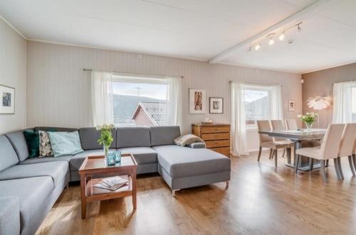 a living room with a couch and a table at Sentrumsnær enebolig in Tromsø