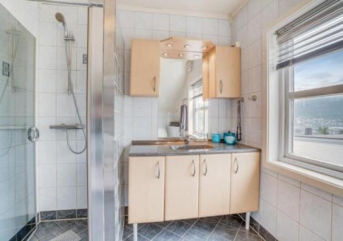 a bathroom with a sink and a shower at Sentrumsnær enebolig in Tromsø