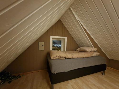 a bed in the middle of a room in a attic at Sentrumsnær enebolig in Tromsø