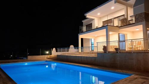 ein Swimmingpool vor einem Haus bei Nacht in der Unterkunft Panoramic Seacave Cottage in Peyia