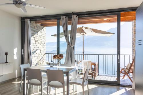 a dining room with a table and chairs and a balcony at Il Giardino Di Lory in Vercana