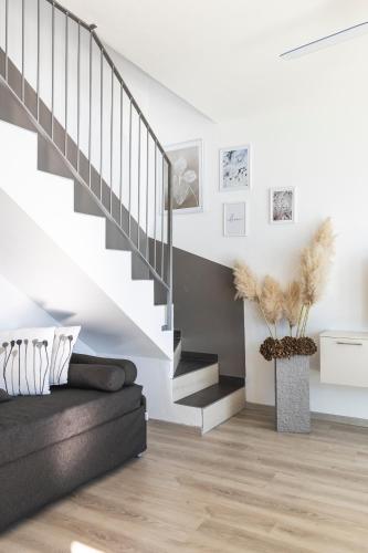 a living room with a black couch and stairs at Il Giardino Di Lory in Vercana