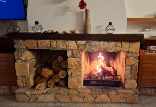 einen Steinkamin mit Kamin in der Unterkunft Panoramic Seacave Cottage in Peyia