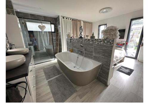 une grande salle de bain avec une baignoire et un lavabo dans l'établissement Ma Maison cote bassin, à Audenge