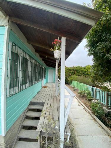 a porch of a blue house with a flower planter on it at Casa para 4 personas sector península Tongoy in Tongoy