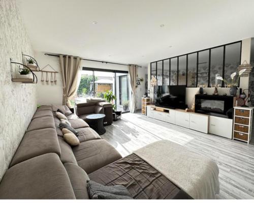 - un salon avec un grand canapé et une télévision dans l'établissement Ma Maison cote bassin, à Audenge