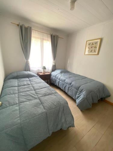 a bedroom with two beds and a window at Casa para 4 personas sector península Tongoy in Tongoy
