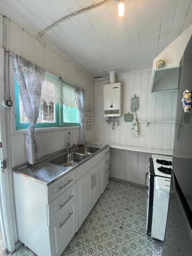 a white kitchen with a sink and a stove at Casa para 4 personas sector península Tongoy in Tongoy