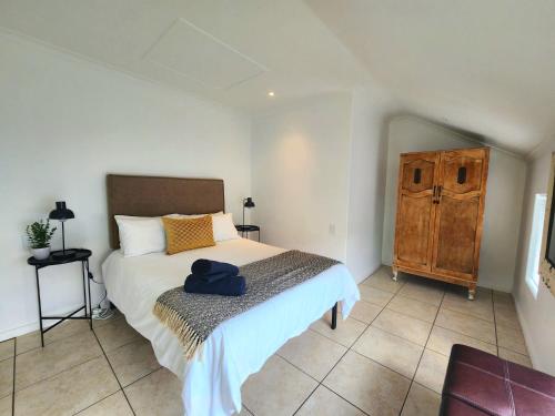 a bedroom with a bed and a wooden cabinet at This Is Not The Post Office in Riebeek-Kasteel