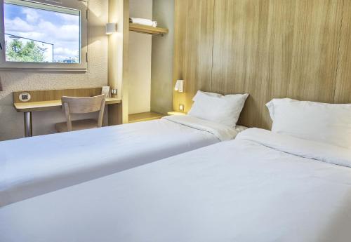 Ένα ή περισσότερα κρεβάτια σε δωμάτιο στο B&B HOTEL Angoulême