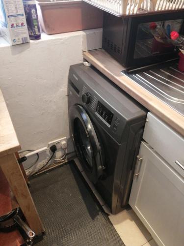 a microwave sitting on top of a washing machine at 42 Churchbury Rd, Room 3 in Eltham
