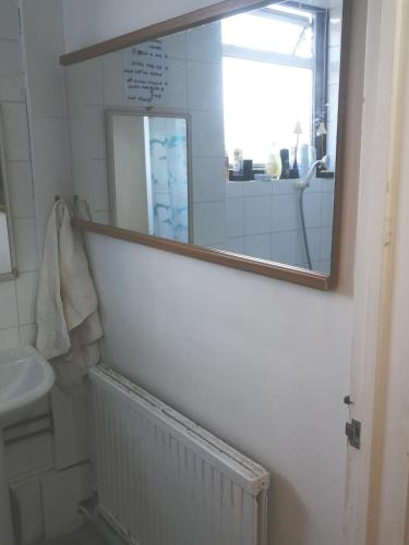 a bathroom with a mirror and a sink at 42 Churchbury Rd, Room 3 in Eltham