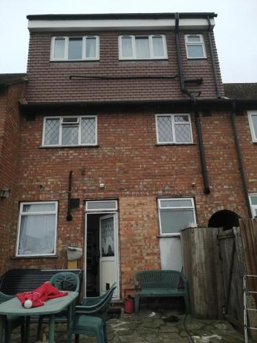 a brick house with a teddy bear on a table outside at 42 Churchbury Rd, Room 3 in Eltham