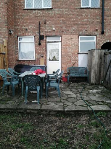 a patio with a table and chairs in front of a brick building at 42 Churchbury Rd, Room 3 in Eltham