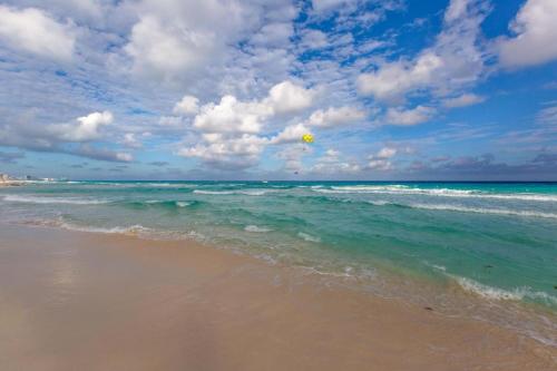 a kite flying over the ocean on a beach at Sea Bloom in Cancún