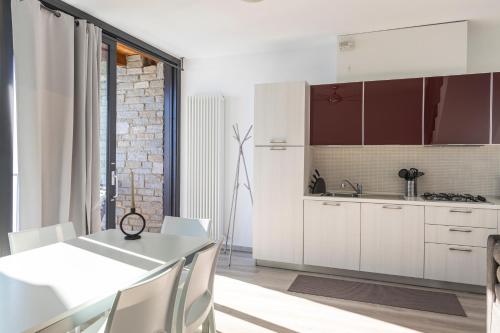 a kitchen with white cabinets and a table with chairs at Il Giardino Di Lory in Vercana