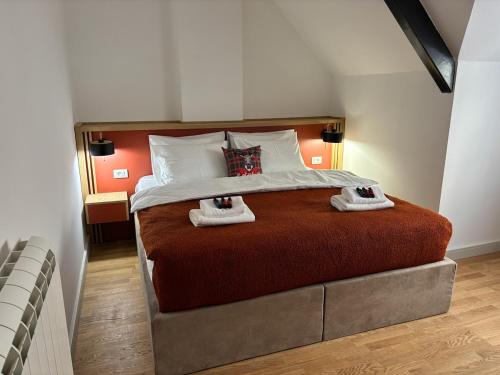 a bedroom with a large bed with two towels on it at Montagna Apartments in Kolašin