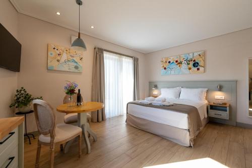 a hotel room with a bed and a table and a table at Kannas Mani Luxury Suites -Adults Friendly 14 Plus in Stoupa