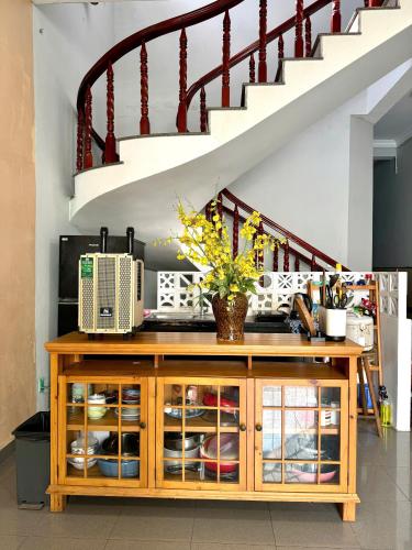 a wooden cabinet in a room with a staircase at Sun Home - Gần Cột Cờ Bãi Sau - Free Bida - Karaoke in Vung Tau