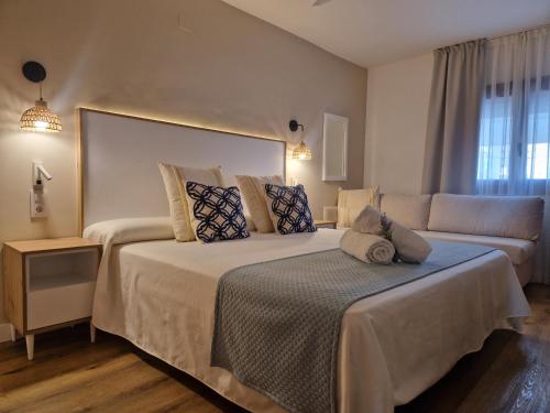 a hotel room with two beds and a couch at Hotel Bodegón de Peñíscola in Peñíscola