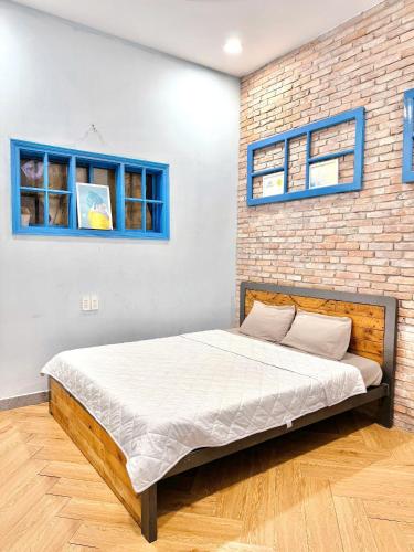 a bed in a room with a brick wall at Sun Home - Gần Cột Cờ Bãi Sau - Free Bida - Karaoke in Vung Tau