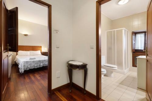 espejo en el baño con cama y aseo en Quinta da Ataíde - Turismo Rural, en Rendufe