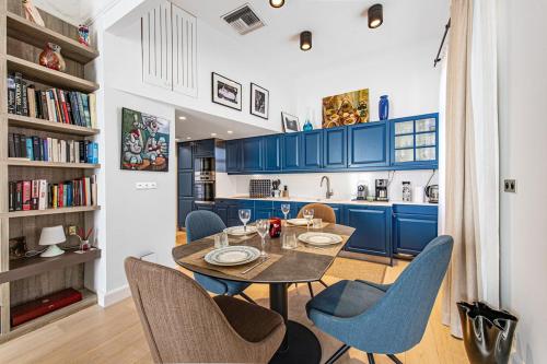 une cuisine avec des armoires bleues et une table et des chaises dans l'établissement Le malte, à Menton