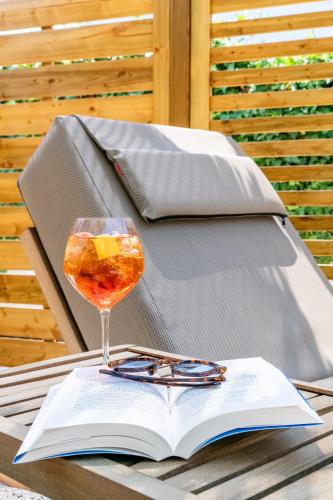 an open book and a glass of wine on a table at Vournelis Beach Hotel and Spa in Iraklitsa