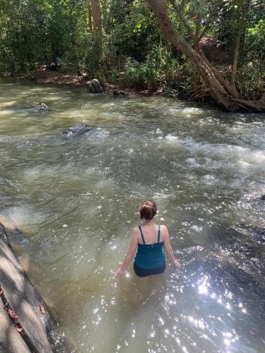 a woman standing in the water in a river at Sahana Retreat in Buttala