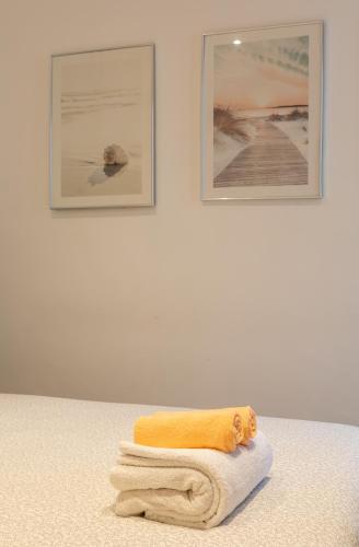 une pile de serviettes assises sur une table avec deux photos dans l'établissement Vieil Antibes, 3 min plage de la Gravette, à Antibes