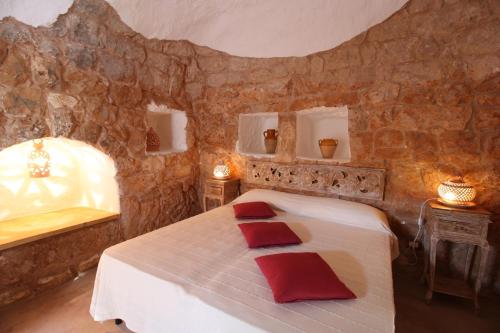 a bedroom with a bed with red pillows on it at Tenuta Zahir in Marina di Mancaversa