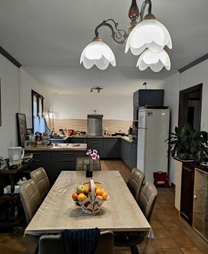 une cuisine avec une table avec un bol de fruits dessus dans l'établissement Maison 6Pers, proche plages et commerces Guidel, à Guidel