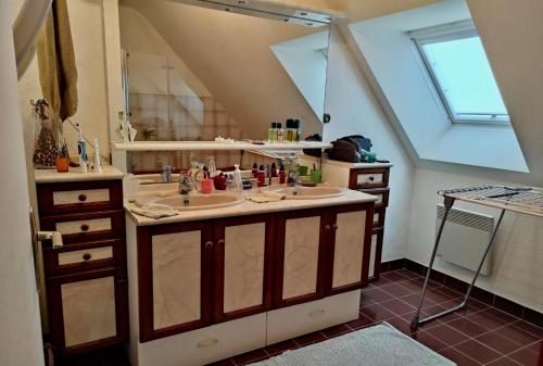 une salle de bain avec deux lavabos et un grand miroir dans l'établissement Maison 6Pers, proche plages et commerces Guidel, à Guidel