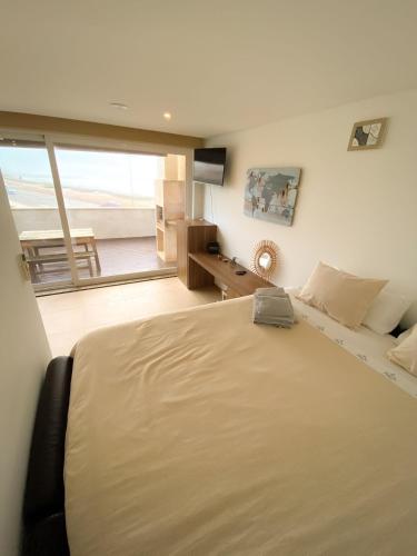 a bedroom with a large bed and a large window at MARESIA APART T0 - Praia do Furadouro in Ovar