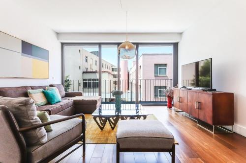 a living room with a couch and a tv at Alcantara Lovely With Balcony 2 Bdr Apt with AC in Lisbon