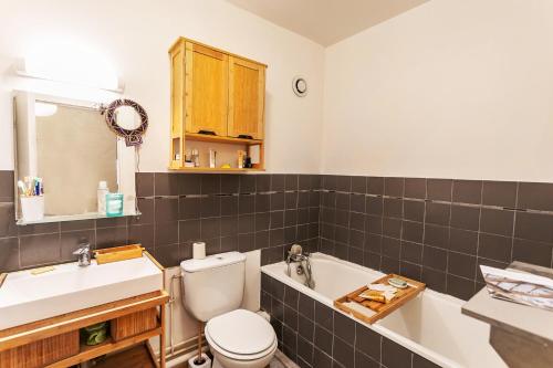 une salle de bain avec toilettes, lavabo et baignoire dans l'établissement Nid douillet Romainville, à Romainville