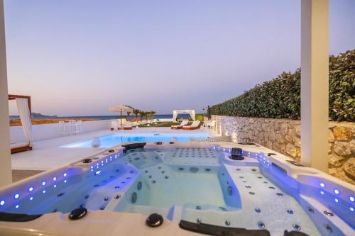 a large swimming pool in the middle of a house at Charisma Beach Front Villa in Kolimbia